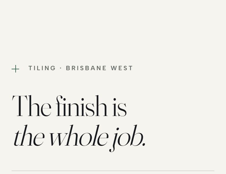 The tiling build: a bone coloured page, a high contrast serif headline set in two lines, and a finished bathroom running off the right edge.